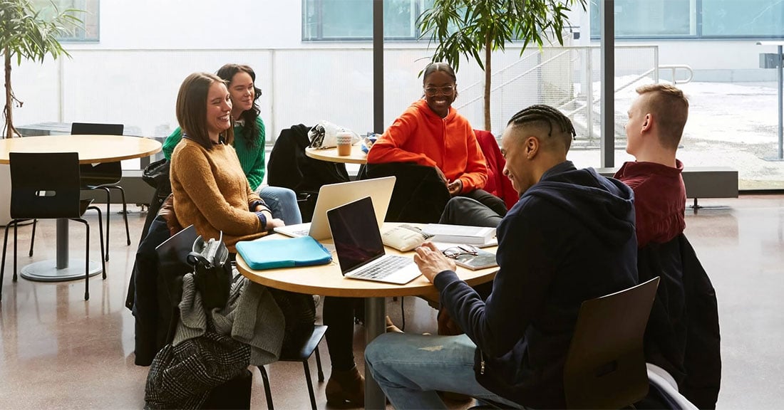 A diverse group of college students sitting around a table working amiably