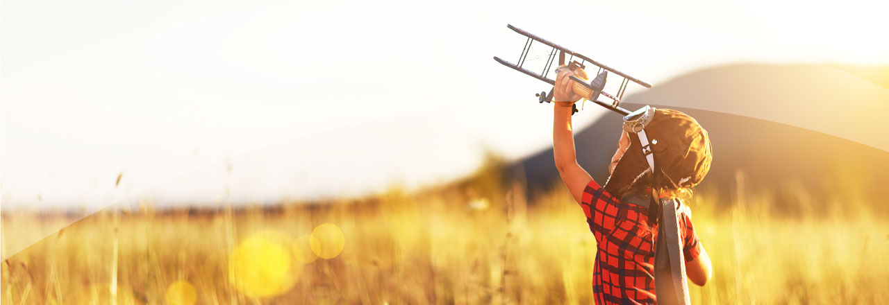 Boy running with an air plane in his hand