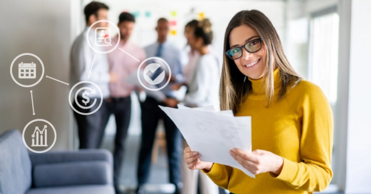 A smiling woman in a yellow turtle neck with glasses looks up from 3 sheets of paper she's holding. She's standing in an office with people in the background. Icons representing strategies overlay the image.