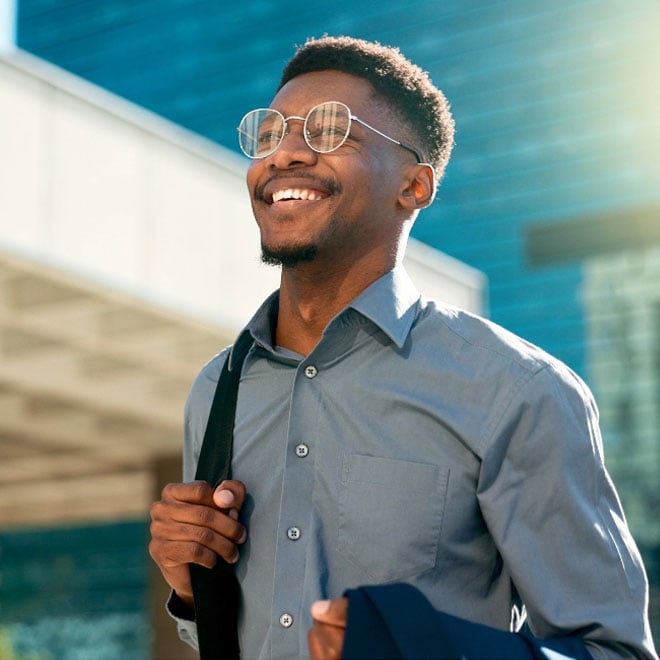 A happy employee with student loan repayment benefits smiles into the future.