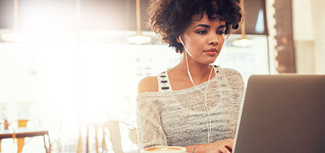 Woman with headphones working on laptop