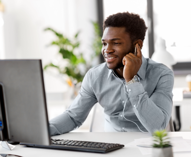 Man using computer and speaking on phone