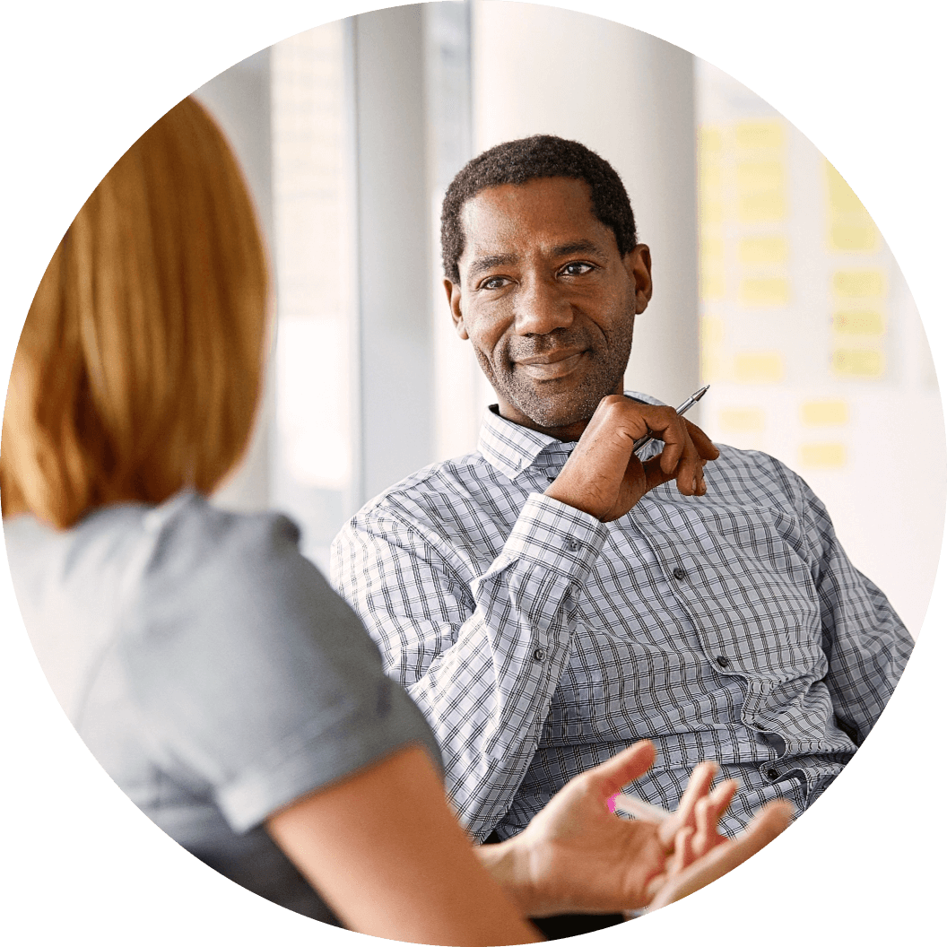 Woman speaking to a man holding a pen