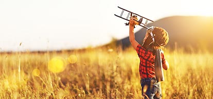 Boy running with an air plane in his hand