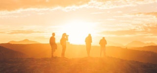 multiple people standing on a hill