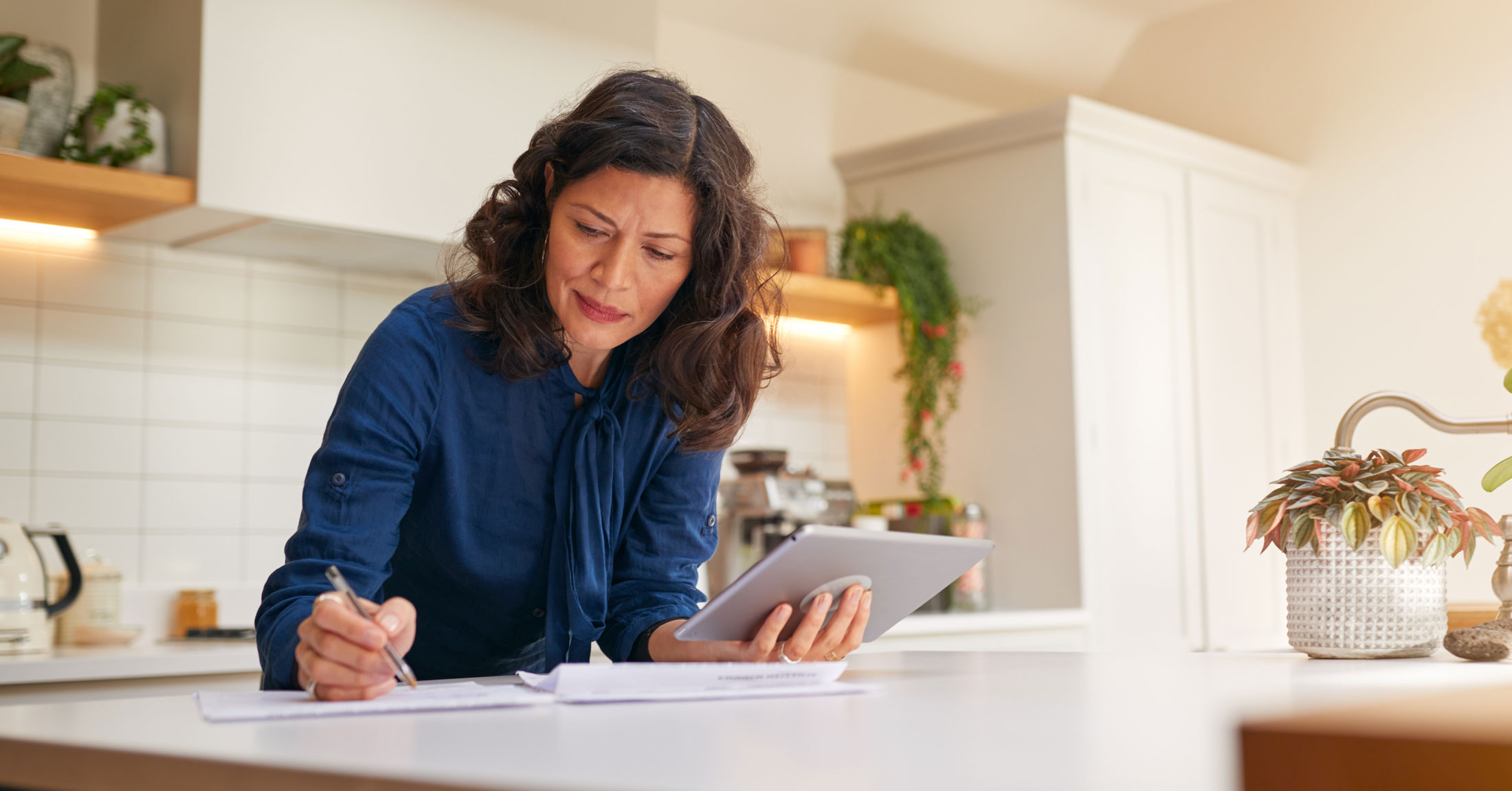 woman doing finances at her kitchen counter