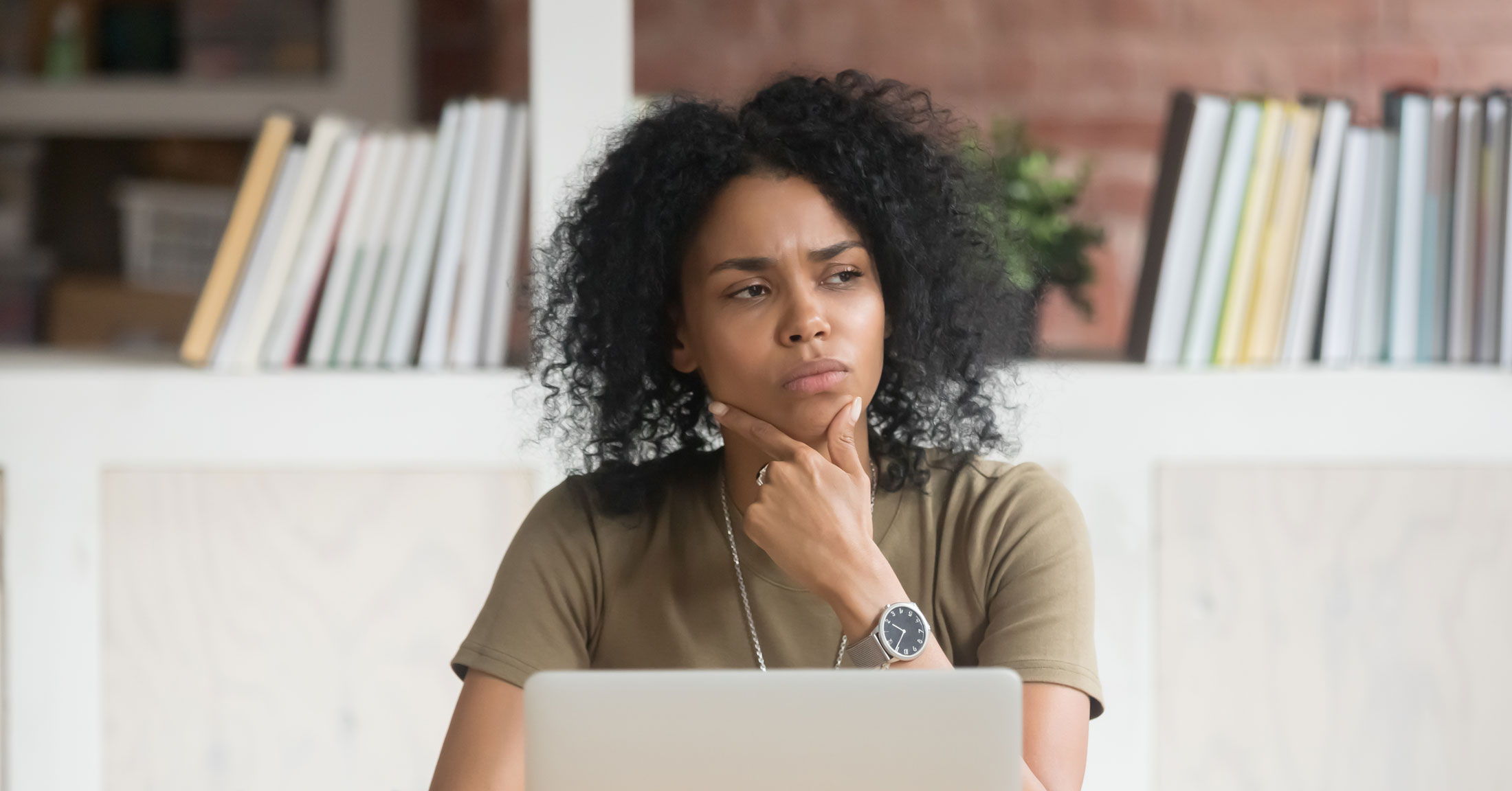 woman contemplating behind a laptop 