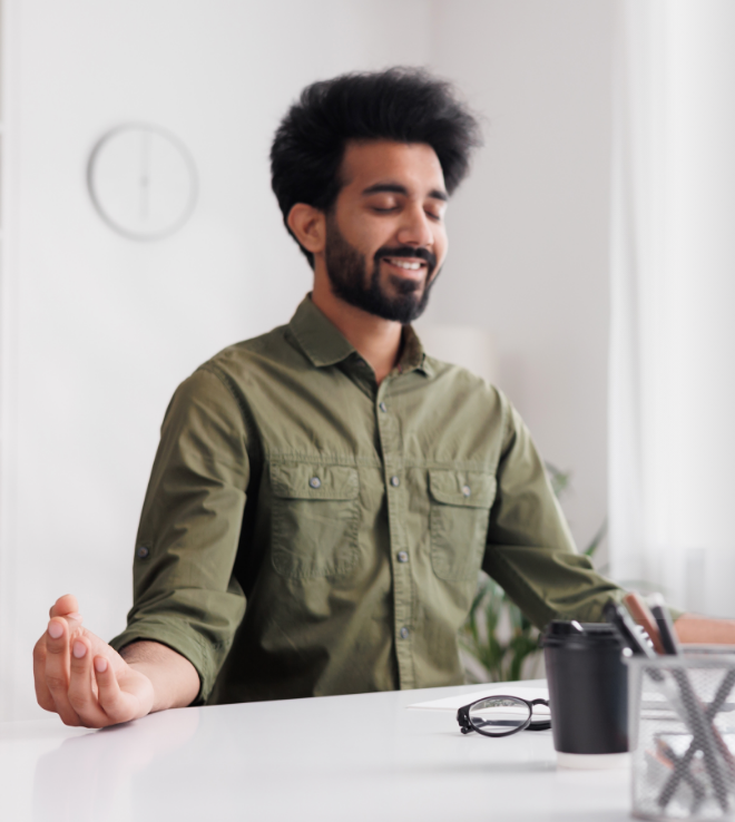 A smiling man at peace at his work desk.